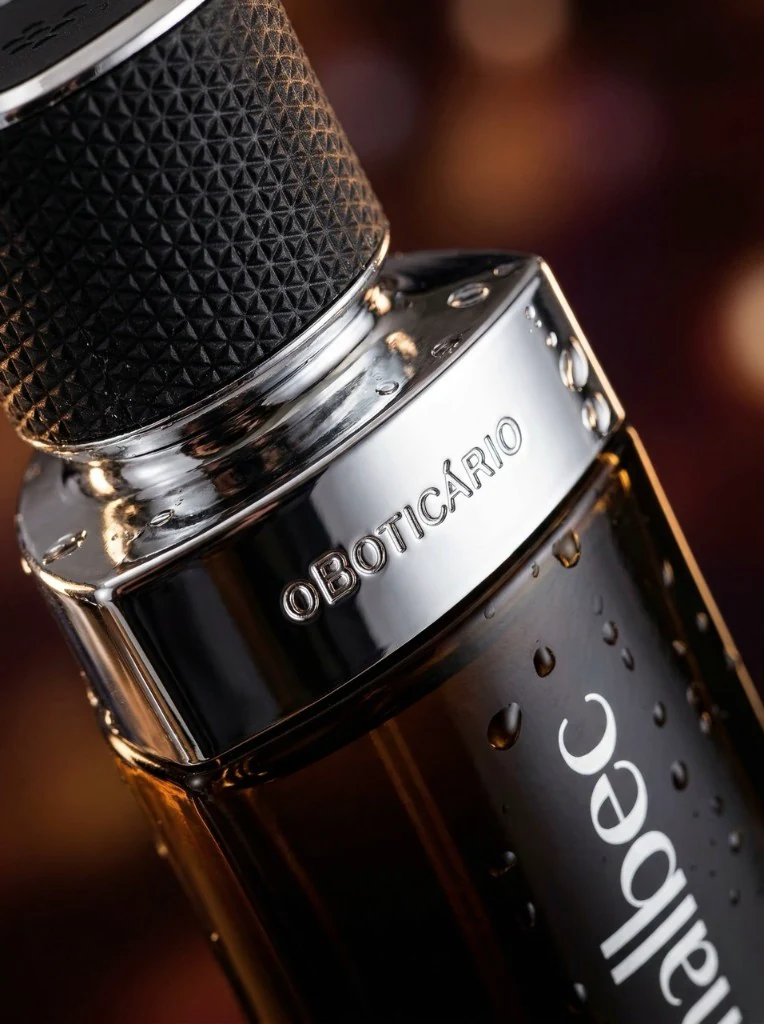 Macro do frasco Malbec: vidro âmbar, metal e gotas